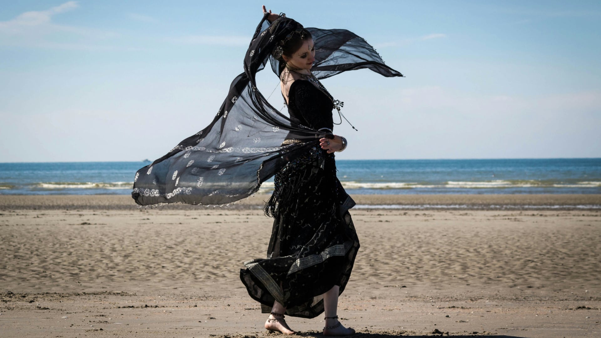 a romani woman dancing on a beach